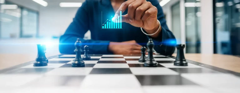 Main de femme directrice marketing en tenue décontractée, tenant un graphique holographique lumineux bleu au-dessus d'un échiquier traditionnel dans un bureau moderne blanc.